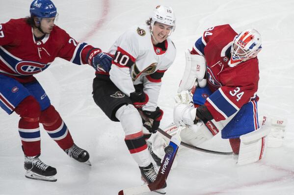 Montreal Canadiens goaltender Jake Allen clears the puck as Ottawa Senators' Alex Formenton (10) and Canadiens' Alexander Romanov (27) move in during the third period of an NHL hockey game Saturday, March 19, 2022, in Montreal. (Graham Hughes/The Canadian Press via AP)