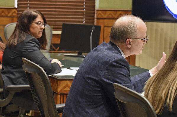 North Dakota Special Assistant Attorney General Dan Gaustad argues before South Central District Judge Bruce Romanick, not pictured, in a hearing Wednesday, Dec. 20, 2023, in Bismarck, N.D, over the state's revised abortion laws. At left is Meetra Mehdizadeh, attorney for the Center for Reproductive Rights, who argued on behalf of the Red River Women's Clinic, which has sued over the abortion ban. (Tom Stromme/The Bismarck Tribune via AP)
