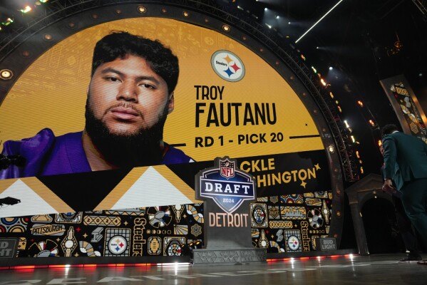 Cameron Heyward, winner of the Walter Payton Man of the Year award, right, stands on stage after announcing a pick by the Pittsburgh Steelers during the first round of the NFL football draft, Thursday, April 25, 2024, in Detroit. (AP Photo/Jeff Roberson)