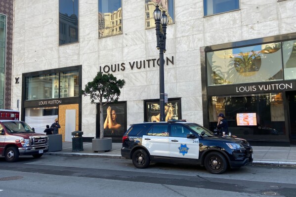 FILE - Police officers and emergency crews park outside the Louis Vuitton store in San Francisco's Union Square on Nov. 21, 2021, after looters ransacked businesses. Facing mounting pressure to crack down on a retail theft crisis, California lawmakers are split on how best to tackle the problem that some say had caused major store closures and products like deodorants to be locked behind plexiglass. (Danielle Echeverria/San Francisco Chronicle via AP, File)