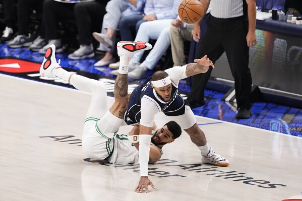 Dallas Mavericks center Daniel Gafford, top, and Boston Celtics forward Jayson Tatum, bottom, chase a loose ball during the second half in Game 4 of the NBA basketball finals, Friday, June 14, 2024, in Dallas. (AP Photo/Sam Hodde)