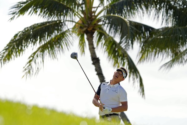 Carl Yuan watches his shot on the 14th tee during the second round of the Sony Open golf event, Friday, Jan. 12, 2024, at Waialae Country Club in Honolulu. (AP Photo/Matt York)