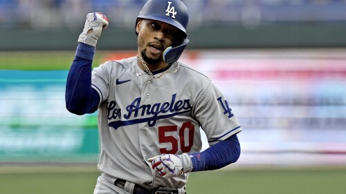 Los Angeles Dodgers' Mookie Betts celebrates as he runs the bases after hitting a solo home run during the first inning of a baseball game against the Kansas City Royals Friday, June 30, 2023, in Kansas City, Mo. (AP Photo/Charlie Riedel)