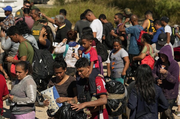 FILE - Migrants wait to be processed by the U.S. Customs and Border Patrol after they crossed the Rio Grande and entered the U.S. from Mexico, Oct. 19, 2023, in Eagle Pass, Texas. A recent decline in arrests for illegal crossings on the U.S. border with Mexico may prove only temporary. The drop in January reflects how numbers ebb and flow, and the reason usually goes beyond any single factor. (AP Photo/Eric Gay, FILE)