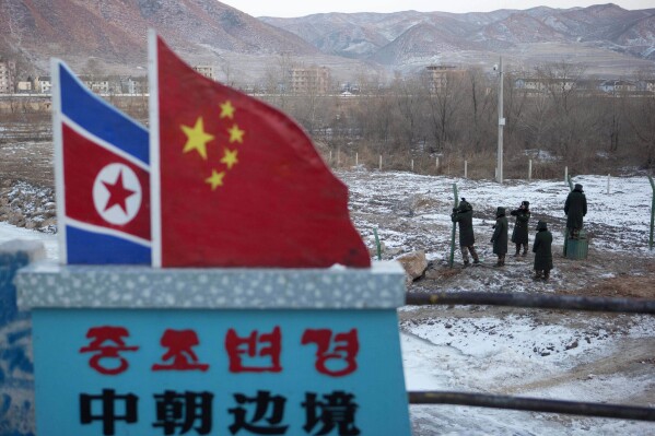 FILE - Chinese paramilitary policemen build a fence near a concrete marker depicting the North Korean and Chinese national flags with the words "China North Korea Border" at a crossing in the Chinese border town of Tumen in eastern China's Jilin province on Dec. 8, 2012. Zhao Leji, a top Chinese leader will lead a delegation to North Korea this week, both countries announced Tuesday, April 9, 2024.(AP Photo/Ng Han Guan, File)