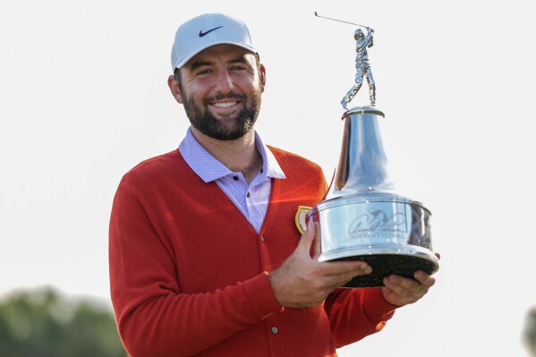 Scottie Scheffler holds the championship trophy after winning the Arnold Palmer Invitational golf tournament Sunday, March 10, 2024, in Orlando, Fla. (AP Photo/John Raoux)