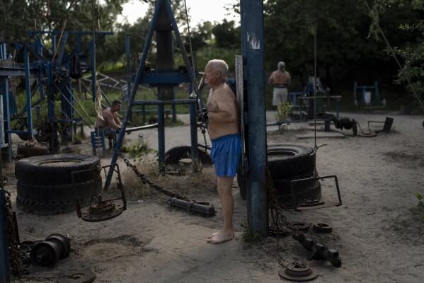 FILE - A man works out using equipment built with scrap metal at the Kachalka outdoor gym in Kyiv, Ukraine, Wednesday, July 12, 2023. The outdoor gym, located on Dolobetskyi island of the capital city, opened in 1966. (AP Photo/Jae C. Hong, File)