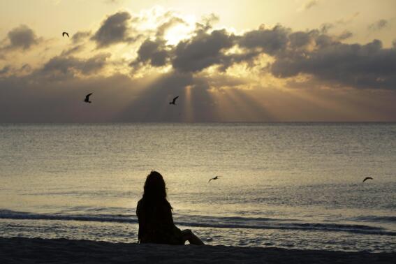 FILE - A woman meditates on the beach in Miami Beach, Fla., on Wednesday, April 28, 2010. According to a study published Wednesday, Nov. 9, 2022 in the journal JAMA Psychiatry, mindfulness meditation worked as well as a standard drug for treating anxiety in the first head-to-head comparison. (AP Photo/Lynne Sladky, File)