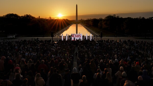 FILE - The word "Jesus" is displayed on a large monitor and worship songs are played on stage as people gather for the "Easter Sunrise Service" at the Lincoln Memorial, Sunday, April 9, 2023, in Washington, hosted by the National Community Church. (AP Photo/Carolyn Kaster, File)