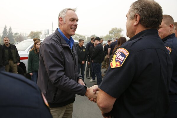 
              File - In this Nov. 14, 2018 file photo, U.S. Secretary of the Interior Ryan Zinke , left, talks with Matthew Watkins of the California Department of Forestry and Fire Protection after touring the fire ravaged town of Paradise, Calif. The Federal Emergency Management Agency says it has distributed more than $20 million in assistance for people displaced by Northern California's catastrophic wildfire. FEMA spokesman Frank Mansell told The Associated Press that $15.5 million has been spent on housing assistance and $5 million on other needs like funeral expenses. Zinke and US Agriculture Secretary Sonny Perdue were scheduled to visit the community of Paradise, which was incinerated by the fire that ignited in the parches Sierra Nevada foothills Nov. 8 and quickly spread across 240 square miles (620 square kilometers).(AP Photo/Rich Pedroncelli, File)
            