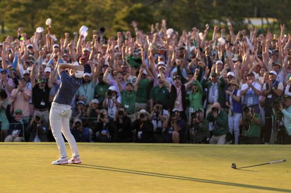 A crowd cheers as Rory McIlroy, of Northern Ireland, celebrates winning at the end of the Masters golf tournament, in Augusta, Ga., April 13, 2025, (AP Photo/Ashley Landis)