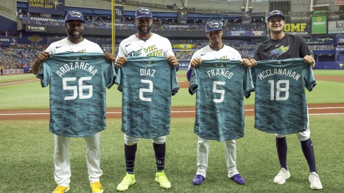 Some of the Tampa Bay Rays representing the team at the All-Star Game, Randy Arozarena, Yandy Diaz, Wander Franco and Shane McClanahan, from left, receive their jerseys prior to the team's baseball game against the Atlanta Braves on Friday, July 7, 2023, in St. Petersburg, Fla. (AP Photo/Mike Carlson)