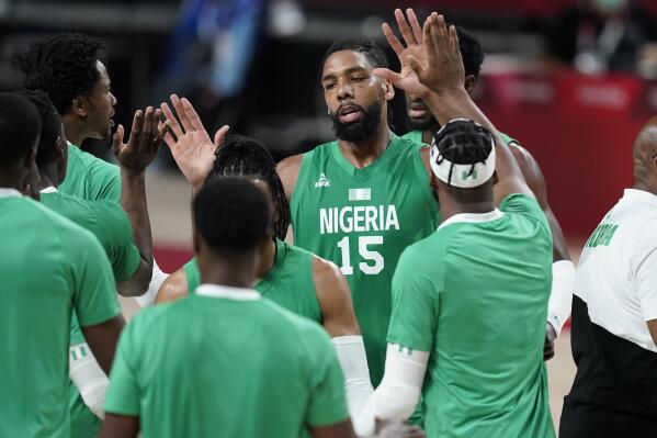 FILE - Nigeria's Jahlil Okafor (15), center, celebrates with teammates after making a basket during men's basketball preliminary round game against Italy at the 2020 Summer Olympics, July 31, 2021, in Saitama, Japan. The Nigerian government has made a sudden U-turn and cleared its national basketball teams to return to competition immediately. The sports ministry on Thursday, June 23, 2022 says the decision to lift a ban on the teams playing in international competitions came after an appeal to the government by the Nigerian Basketball Federation. (AP Photo/Charlie Neibergall, file)