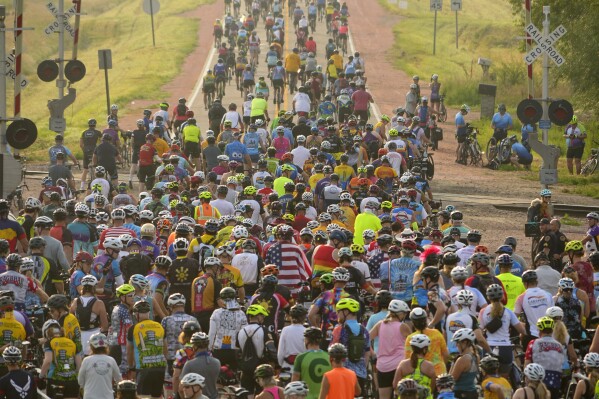 Riders, participant à RAGBRAI 50, (Register's Annual Great Bicycle Ride Across Iowa), lents à traverser les voies ferrées en sortant de Sioux City, Iowa, le dimanche 23 juillet 2023. (Zach Boyden-Holmes/The Des Moines Register via AP)