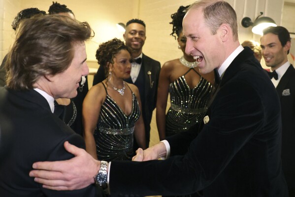 Britain's Prince William, the Prince of Wales, right, reacts as he speaks with US actor Tom Cruise, at the London Air Ambulance Charity Gala Dinner at The OWO in central London, Wednesday, Feb. 7, 2024. (Daniel Leal/Pool Photo via AP)