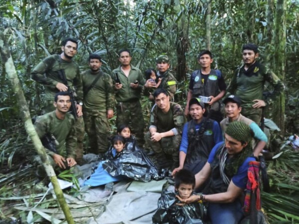 FILE - In this photo released by Colombia's Armed Forces Press Office, soldiers and Indigenous men pose for a photo with the four children who were missing after surviving a deadly plane crash, in the Solano jungle, Caqueta state, Colombia, June 9, 2023. (Colombia's Armed Force Press Office via AP, File)