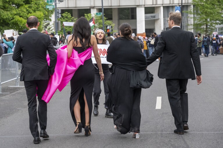 Um manifestante protesta enquanto convidados chegam ao Jantar da Associação de Correspondentes da Casa Branca no Washington Hilton, sábado, 27 de abril de 2024, em Washington.  (Foto AP/Kevin Wolff)