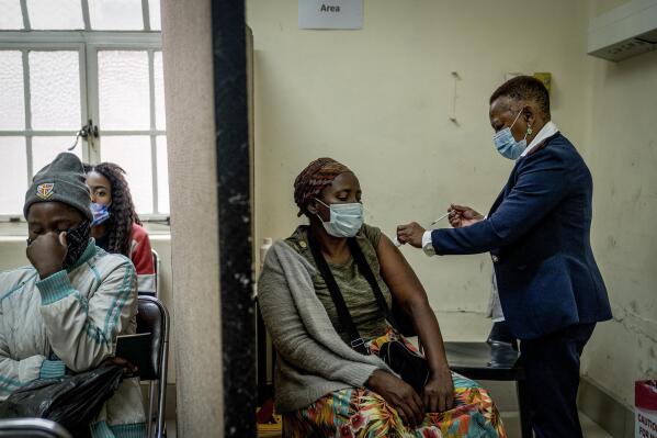 A woman is vaccinated against COVID-19 at the Hillbrow Clinic in Johannesburg, South Africa, Monday Dec. 6, 2021. South African doctors say the rapid increase in COVID-19 cases attributed to the new omicron variant is resulting in mostly mild symptoms. (AP Photo/ Shiraaz Mohamed)