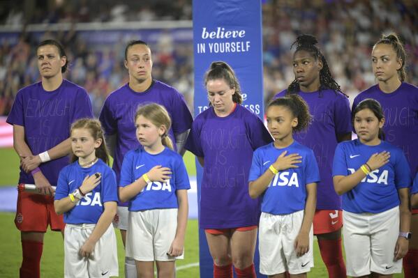Canada players wear purple shirts with "Enough is Enough" written on them during the national anthems before the team's SheBelieves Cup soccer match against the United States, Thursday, Feb. 16, 2023, in Orlando, Fla. (AP Photo/Phelan M. Ebenhack)