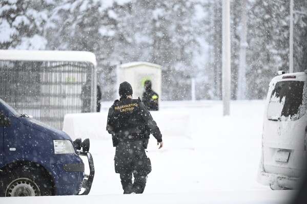Finnish border guards walk through the snow at the Radja Joseppi border crossing between Russia and Finland in Inari, northern Finland, Saturday, November 25, 2023. The European Union's border protection agency said it would deploy dozens of police officers and border checkpoints. Reinforcement equipment has been provided to Finland to help with border security amid suspicions that Russia is behind the influx of migrants into Finland.  (Emi Korhonen/Retikva, via AP)