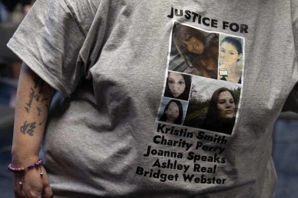 A person wears a T-shirt with the names of Kristin Smith, Charity Lynn Perry, Joanna Speaks, Ashley Real, and Bridget Webster on it during a news conference on Friday, May 17, 2024, in Portland, Ore. A grand jury indicted Jesse Lee Calhoun, on second-degree murder charges in the deaths of Charity Lynn Perry, 24; Bridget Leanne Webster, 31; and Joanna Speaks, 32, the Multnomah County district attorney announced Friday. (Ǻ Photo/Jenny Kane)