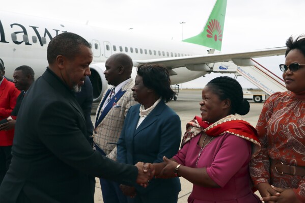 FILE - Malawi Vice President Saulos Chilima, left, greets government officials upon his return from South Korea in Lillongwe, Sunday, June 9, 2024. Malawi’s vice president and nine others have been killed in a plane crash, the country’s president said Tuesday. The wreckage of the military plane carrying Vice President Saulos Chilima was located in a mountainous area in the north of the country after a search that lasted more than a day. There were no survivors of the crash, Malawian President Lazarus Chakwera said. Chakwera made the announcement in a live address on state television. (AP Photo, File)