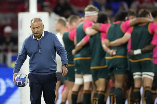 Australia's head coach Eddie Jones holds a rugby ball during the warm-up before the Rugby World Cup Pool C match between Wales and Australia at the OL Stadium in Lyon, France, Sunday, Sept. 24, 2023. (AP Photo/Christophe Ena)