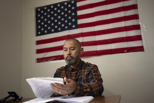 FILE - Chinese migrant Li Kai aka Khaled, an ethnic Hui Muslim, studies for a Commercial Driving License in his apartment in Flushing, New York, May 3, 2024. Li Kai came to the U.S. with his wife and two sons seeking religious freedom and a better life. (AP Photo/Serkan Gurbuz, File)