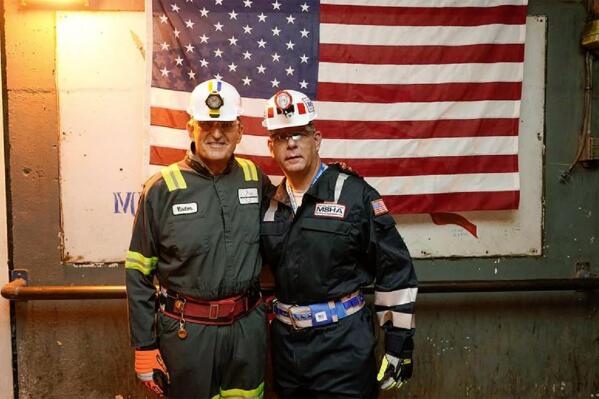 In this photo released by the Office of U.S. Sen. Joe Manchin, D-W.Va., Manchin, left, poses with U.S. Labor Secretary Marty Walsh Wednesday, Aug. 18, 2021, during a tour of an underground coal mine, in Dallas, W.Va. (Office of U.S. Sen. Joe Manchin via AP)