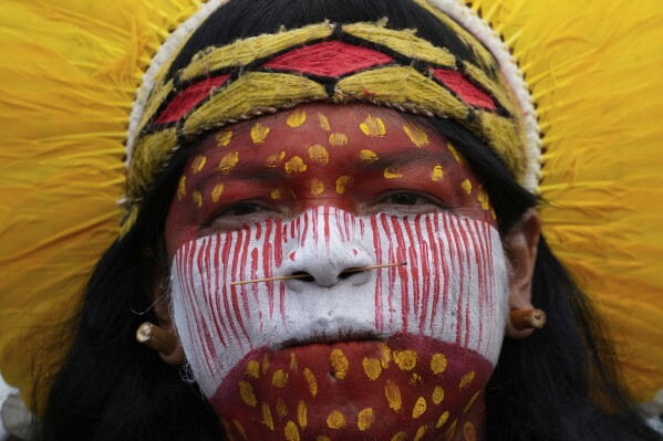 An Indigenous woman attends in the annual Free Earth camp where Brazil's Indigenous communities discuss rights, territorial protection and their role in COP30 which will take place for the first time in the Amazon, in Brasilia, Brazil, Tuesday, April 8, 2025. (AP Photo/Eraldo Peres)