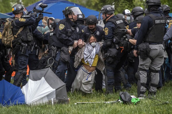 Police lift a pro-Palestinian demonstrator from the ground on the University of Virginia campus, in Charlottesville, Va., where tents are set up, Saturday, May 4, 2024. (Cal Cary/The Daily Progress via AP)