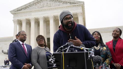 FILE - Evan Milligan, center, plaintiff in Merrill v. Milligan, an Alabama redistricting case, speaks with members of the press following oral arguments outside the Supreme Court on Capitol Hill in Washington, Oct. 4, 2022. Standing behind Milligan are Milligan's counsel Deuel Ross, from left, Letetia Jackson, Rep. Terri Sewell, D-Ala., and Janai Nelson, President and Director-Counsel of the NAACP Legal Defense Fund. The Supreme Court on Thursday, June 8, 2023, issued a surprising ruling in favor of Black voters in a congressional redistricting case, ordering the creation of a second district with a large Black population. (AP Photo/Patrick Semansky, File)