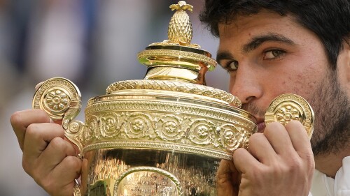 Spain's Carlos Alcaraz celebrates with the trophy after beating Serbia's Novak Djokovic to win the final of the men's singles on day fourteen of the Wimbledon tennis championships in London, Sunday, July 16, 2023. (AP Photo/Kirsty Wigglesworth)