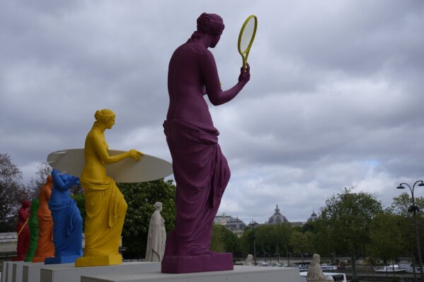 Copies of one of the most famous Greek statues, Venus Milo, are installed on the steps of the French National Assembly in Paris, France, on Monday, April 15, 2024, to celebrate the Olympic Spirit. The flower, by the artist Laurent Perbus, recovered its arms, and is now equipped with the features of six sports. (AP Photo/Christophe Ena)
