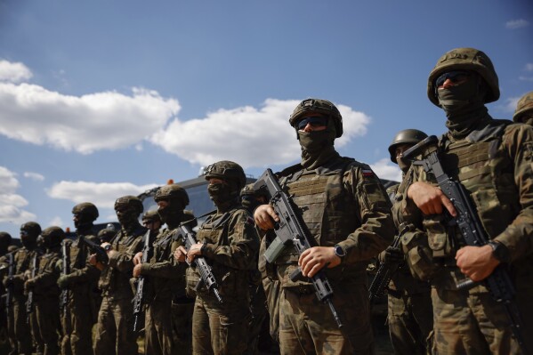 FILE - Polish servicemen attend a press conference of Poland's Minister of Defense, Mariusz Blaszczak, in Jarylowka, Poland, Saturday, Aug. 12, 2023. Poland is deploying thousands of troops to its border with pro-Russian Belarus, calling it a deterrent move as tensions between the neighbors ratchet up. Officials in Belarus have been making hostile comments about Poland, a European Union and NATO member. (AP Photo/Michal Dyjuk, file)