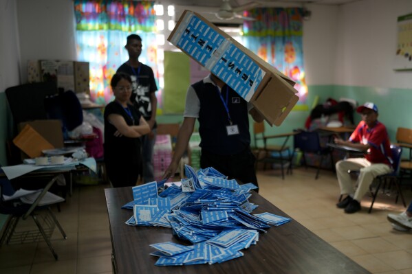 An electoral worker empties a ballot box to count after general elections polls closed in Panama City, Sunday, May 5, 2024. (AP Photo/Matias Delacroix)