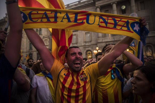 
              A man holds up a scarf as a crowd of pro-independence supporters gathers in the square outside the Palau Generalitat in Barcelona, Spain, after Catalonia's regional parliament passed a motion with which they say they are establishing an independent Catalan Republic, Friday, Oct. 27, 2017. (AP Photo/Santi Palacios)
            