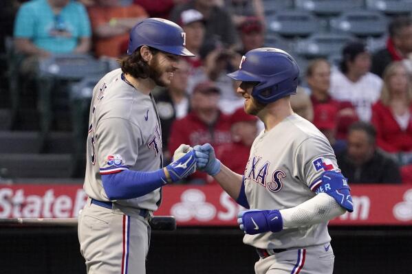 Texas Rangers' Mitch Garver, right, is congratulated by Jonah Heim after hitting a solo home run during the fourth inning of a baseball game against the Los Angeles Angels Wednesday, May 25, 2022, in Anaheim, Calif. (AP Photo/Mark J. Terrill)