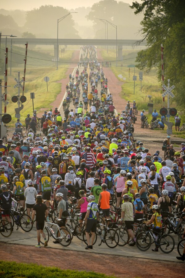 Riders, participating in RAGBRAI 50, (Register’s Annual Great Bicycle Ride Across Iowa), slow to cross train tracks on the way out of Sioux City, Iowa, Sunday, July 23, 2023. (Zach Boyden-Holmes/The Des Moines Register via AP)