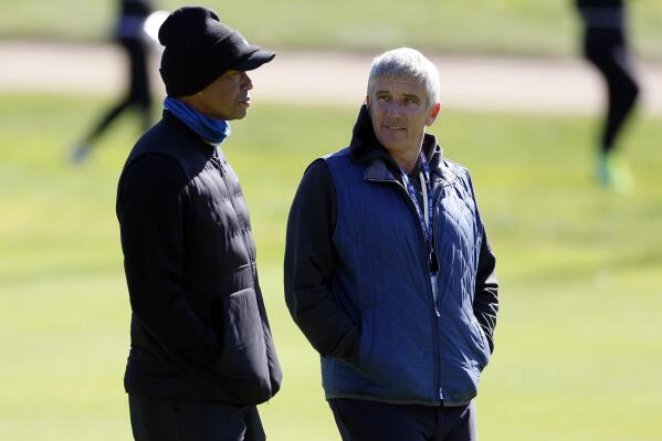 Tiger Woods, left, talks to PGA Commissioner Jay Monahan on the 15th hole during the pro-am of the Genesis Invitational golf tournament at Riviera Country Club, Wednesday, Feb. 15, 2023, in the Pacific Palisades area of Los Angeles. (AP Photo/Ryan Kang)