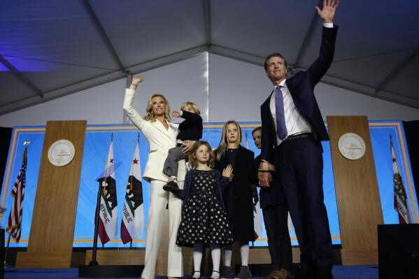 FILE -- In this Jan. 7, 2019 file photo California Governor Gavin Newsom his wife, Jennifer Siebel Newsom, and their children wave after taking the oath office during his inauguration as 40th Governor of California, in Sacramento, Calif. The Newsoms made about $500,000 more in 2019, Gavin Newsom's first year as governor, than they did before, according to tax returns released on May 17, 2021. Newsom, a Democrat, has pledged to release his returns every year. (AP Photo/Rich Pedroncelli, File)