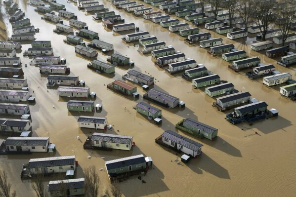 Holiday homes at the Billing Aquadrome in Northampton are surrounded by water caused by Storm Henk on Wednesday, Jan. 3, 2024. A severe flood alert, meaning danger to life, was in place for the River Nene in Northampton, which warned of deep and fast-flowing water at the Billing Aquadrome holiday park and nearby business parks. (Jacob King/PA via AP)