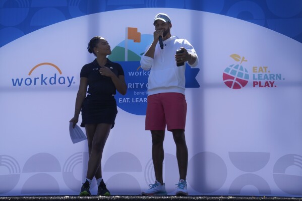 Golden State Warriors basketball player Stephen Curry, right, speaks next to his wife, Ayesha, during a charity event at Stanford Golf Course in Stanford, Calif., Monday, Aug. 28, 2023. The Currys and partners are expanding the reach of their Eat.Learn.Play. Foundation, established in 2019 to support youth in Oakland, the Bay Area and beyond, while striving to improve lives of families nationwide. They are generating $50 million in additional funding to assist the Oakland Unified School District. (AP Photo/Jeff Chiu)