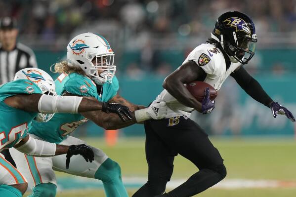 Baltimore Ravens wide receiver Marquise Brown (5) is tackled by Miami Dolphins middle linebacker Duke Riley (45), center, and Miami Dolphins middle linebacker Elandon Roberts (52), during the first half of an NFL football game, Thursday, Nov. 11, 2021, in Miami Gardens, Fla. (AP Photo/Lynne Sladky)