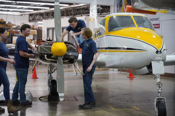 Students at the Pittsburgh Institute of Aeronautics from left: Nikki Reed, William Onderdonk, Jeffrey Natter and Joshua Lindberg study an engine on a Cessna 310 aircraft in West Mifflin, Pa., Tuesday, May 2, 2023. Students graduating from PIA have been awed by how much they're in demand. Recruiters are desperately seeking more aircraft mechanics for the airlines, airplane manufacturers, and repair shops that need them. (AP Photo/Gene J. Puskar)
