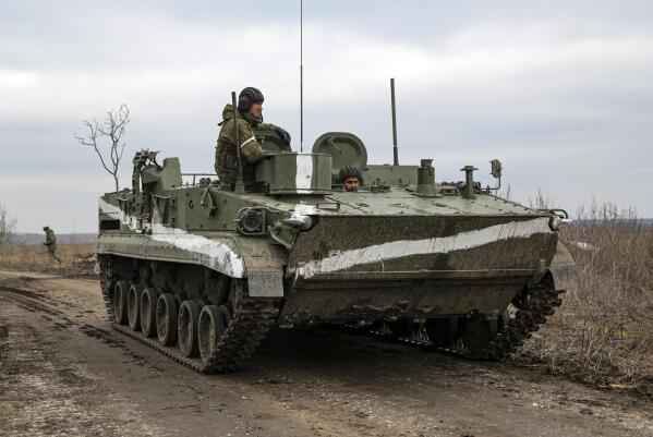 An armored vehicle rolls outside Mykolaivka, Donetsk region, the territory controlled by pro-Russian militants, in eastern Ukraine, Sunday, Feb. 27, 2022. Fighting also raged in two eastern territories controlled by pro-Russia separatists. (AP Photo)
