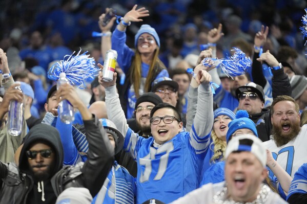 Detroit Lions fans celebrate a touchdown by running back David Montgomery during the first half of an NFL wild-card playoff football game against the Los Angeles Rams, Sunday, Jan. 14, 2024, in Detroit. (AP Photo/Paul Sancya)