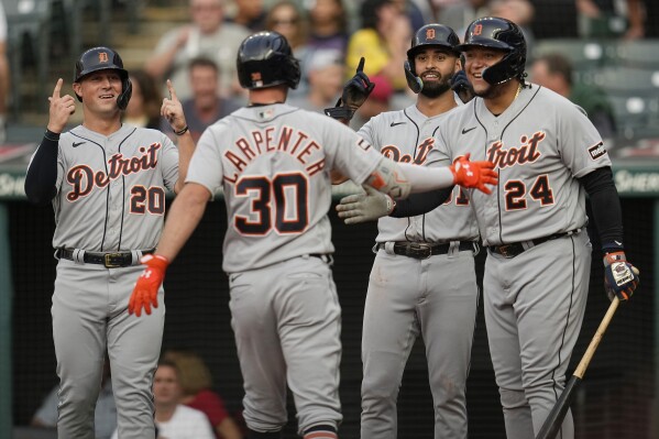 Detroit Tigers' Kerry Carpenter (30) is greeted at the plate by teammates Spencer Torkelson (20), Riley Greene, second from right, and Miguel Cabrera (24), following his home run in the first inning of a baseball game against the Cleveland Guardians, Saturday, Aug. 19, 2023, in Cleveland. (AP Photo/Sue Ogrocki)