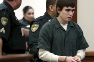 FILE - In this Feb. 25, 2019 file photo, Dimitrios Pagourtzis is escorted by Galveston County Sheriff's Office deputies into a courtroom at the Galveston County Courthouse in Galveston, Texas. A judge has ruled the teenager accused of fatally shooting 10 people at a Texas high school mentally incompetent to stand trial. (Jennifer Reynolds/The Galveston County Daily News via AP, File)
