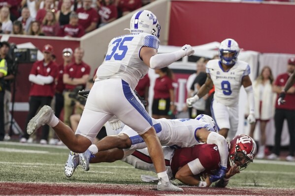 Indiana quarterback Tayven Jackson (2) dives in for a touchdown as he is tackled by Indiana State defensive back Kaleal Davis during the first half of an NCAA college football game Friday, Sept. 8, 2023, in Bloomington, Ind. (AP Photo/Darron Cummings)